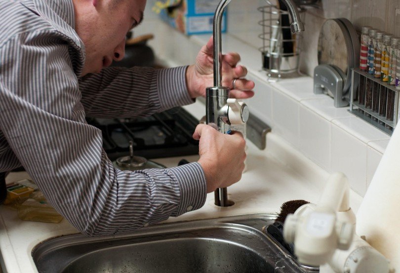 a man replacing kitchen facet